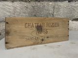 a wooden box with a sign on it sitting in front of a stone wall