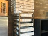 a stack of boxes on a metal rack in a kitchen