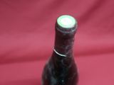 a bottle of wine that is sitting on a red cloth