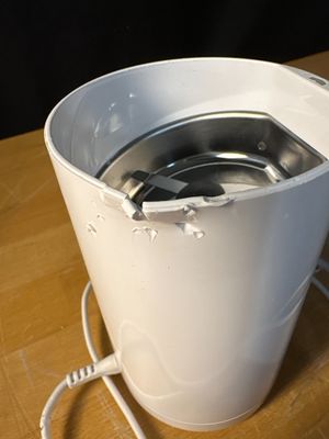 a white bucket with a metal lid sitting on a wooden table
