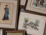 many framed pictures on the wall of a room