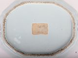 underside view of a blue and white porcelain bowl with a square cut in the middle