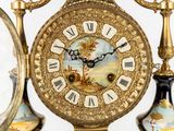 a clock that is sitting on a table with two vases