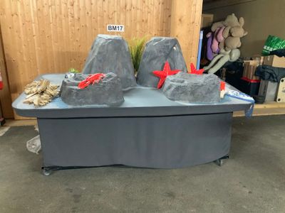 deux gros rochers posés sur une table, sur laquelle est posée une pancarte