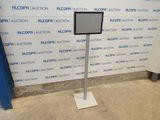 the floor standing sign stands in front of a wall with a blue and white background