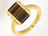 une image représentant une bague en or sertie d'une pierre brune