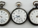 trois types différents de montres de poche sont présentés sur une surface blanche