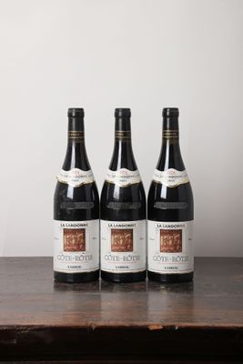 trois bouteilles de vin posées sur une table en bois
