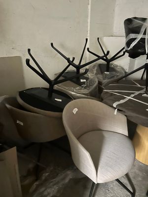 de nombreuses chaises et tabourets dans une pièce où il y a beaucoup d'objets par terre