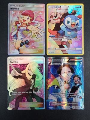 quatre cartes à collectionner Pokémon différentes sont posées sur une surface noire
