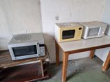 deux micro-ondes posés sur une petite table dans une pièce