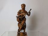 une statue représentant un homme jouant de la guitare sur une table en verre