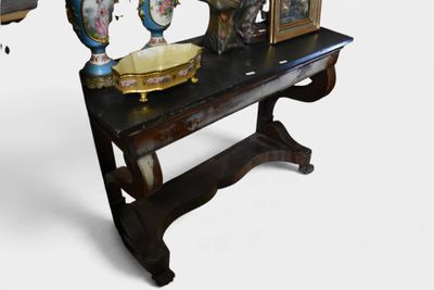une image représentant une table sur laquelle sont posés des vases et des tableaux