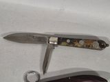 a knife that is laying next to a bottle opener