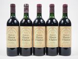 quatre bouteilles de vin sont alignées sur une surface blanche