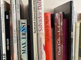 many books that are on a wooden shelf