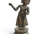 statue en bronze d'une femme tenant un oiseau sur un piédestal