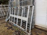 a metal fence that is leaning against a building