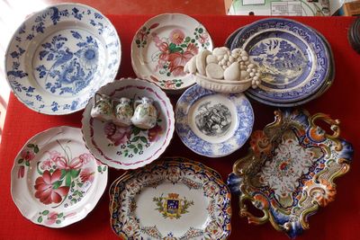 une table rouge sur laquelle sont posés plusieurs assiettes et bols