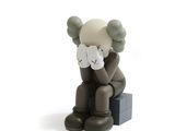une figurine représentant un ours en peluche assis sur une boîte