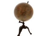 un petit globe en bois posé sur un socle, surmonté d'un oiseau perché