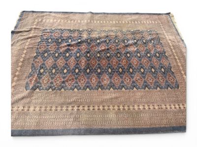 un gros plan d'un tapis bleu et marron posé sur une surface blanche