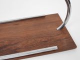 a metal object on a wooden stand on a white surface
