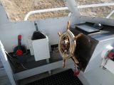 a steering wheel on the side of a boat on the water