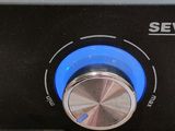 a close up of a black oven with a blue knob