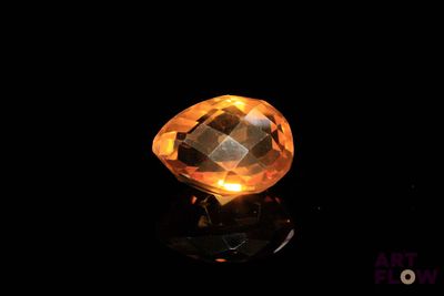 gros plan d'un diamant jaune sur une surface noire