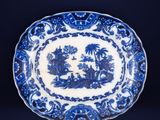 a blue and white plate with a landscape scene on it