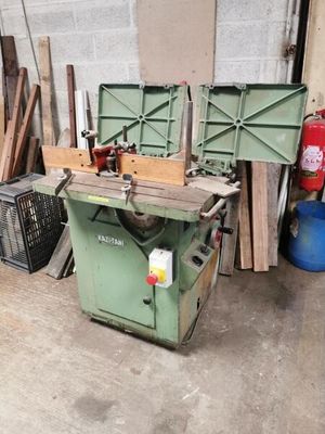 Plusieurs morceaux de bois sont empilés sur une table dans un garage.