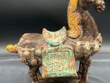 an image of a statue of a horse with a saddle on it ' s back