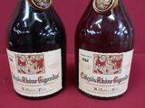 two bottles of wine sitting next to each other on a table