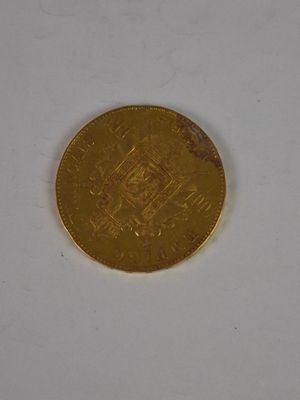 a gold coin on a white surface with a white background