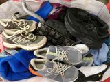 many pairs of shoes in a basket on the floor