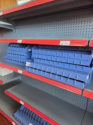 empty shelves in a store with blue bins on them