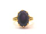 an image of a gold ring with a purple stone in the center