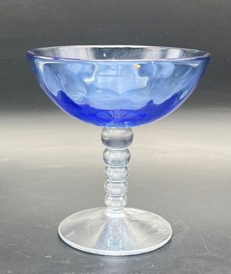 a blue glass bowl sitting on top of a table