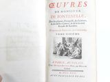 a hand holding an open book with a picture of people on it