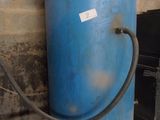 a blue water tank with a hose attached to it