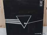 une boîte noire sur laquelle est dessiné un triangle, posée sur une table