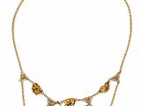 a close up of a gold necklace on a white background