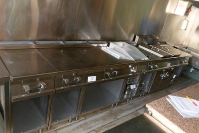 une cuisine avec de nombreux plans de travail en inox