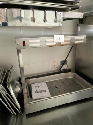 plan de travail en acier inoxydable dans une cuisine professionnelle regorgeant d'ustensiles