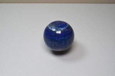 une bille bleue posée sur une surface blanche