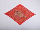 a small red diamond with a picture of a man riding a horse