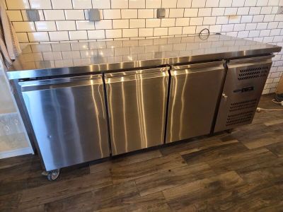 a stainless steel kitchen island in the middle of a kitchen