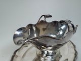 a silver plate with a silver bowl and spoon on it