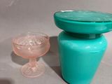 a blue vase and a glass sitting on a table